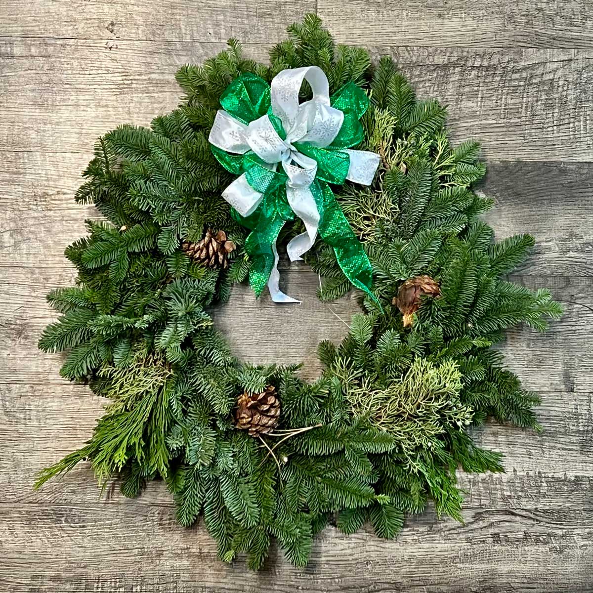 Christmas wreath with pinecones and green bow