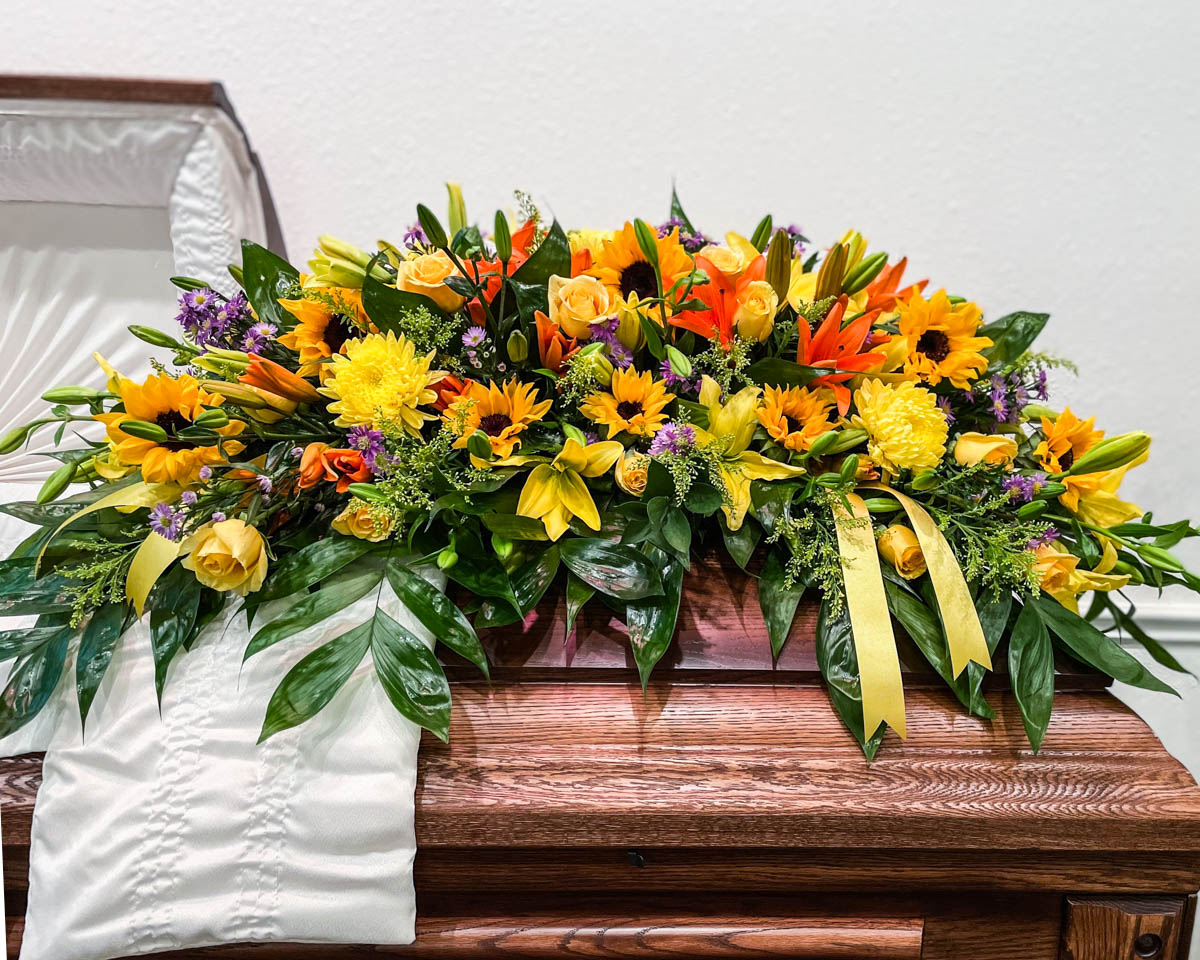 Yellow and orange spring casket cover from Annaville Florist