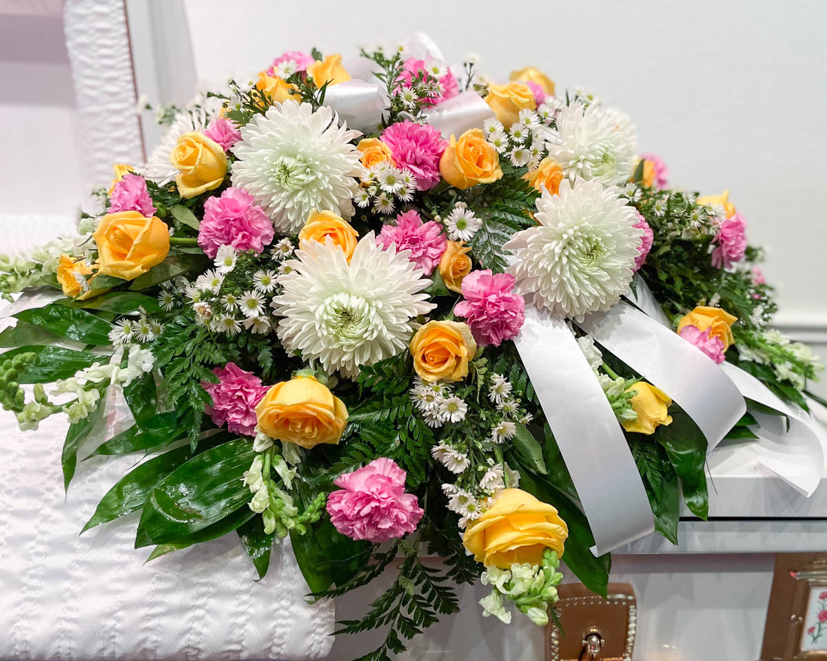 Yellow, pink and white casket cover from Annaville Florist