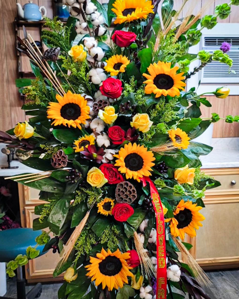 Sunflower and cotton standing funeral spray by Annaville Florist