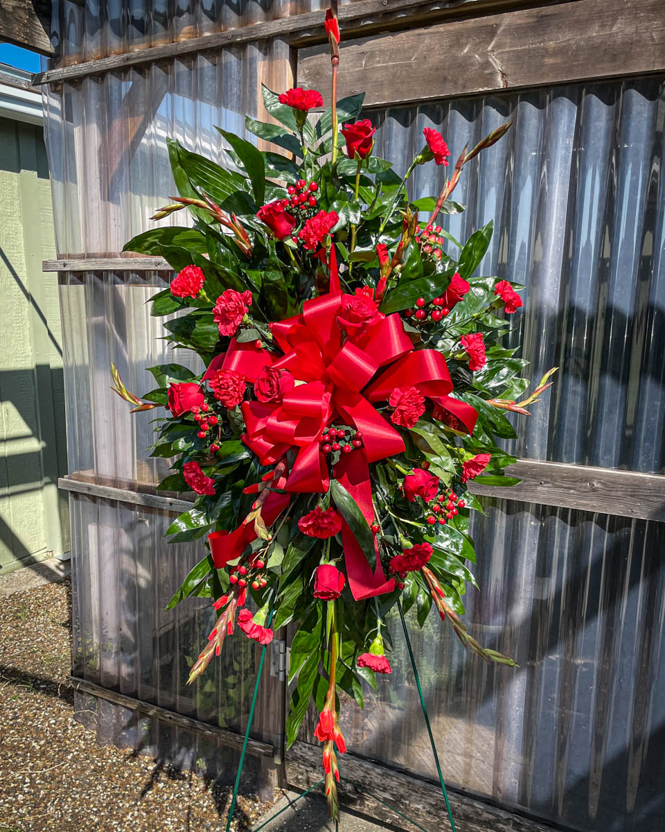 Modern, tapered mixed red funeral spray from Annaville Florist